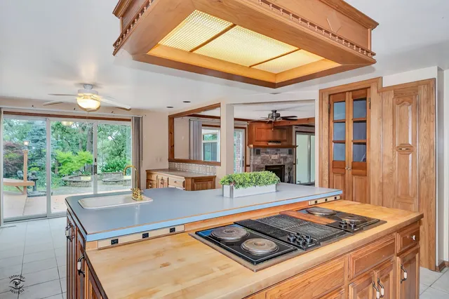 a living room with furniture a ceiling fan a fireplace and a large window