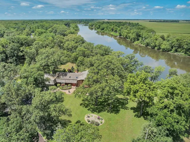 an aerial view of a house with a yard and lake view