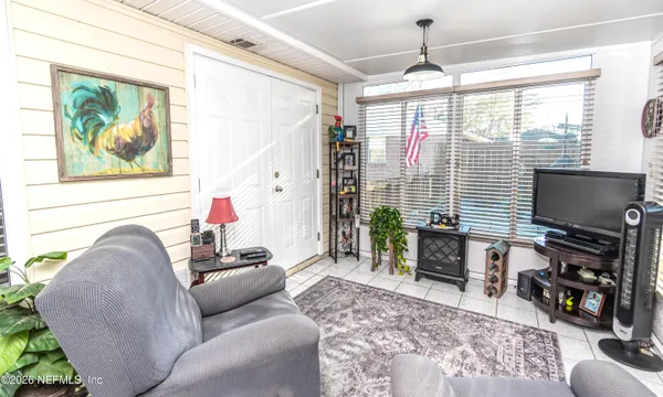 a living room with furniture a flat screen tv and a window