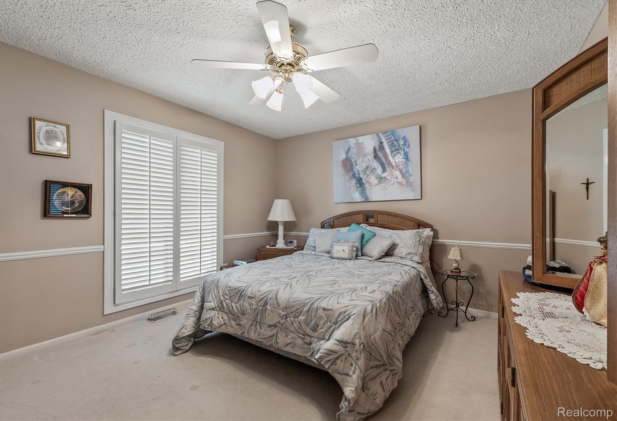 1662 Sumac Drive Rochester, MI 48309 - Photo 23 of 38 Bedroom featuring a ceiling fan with light fixture, plantation shutters, and crown molding