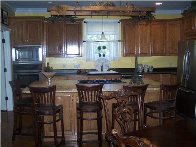 899 Bay Grove Road Freeport, FL 32439 - Photo 3 of 27 a kitchen with granite countertop a table chairs stove and cabinets
