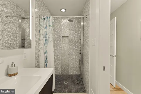 a bathroom with a granite countertop sink a shower and a mirror