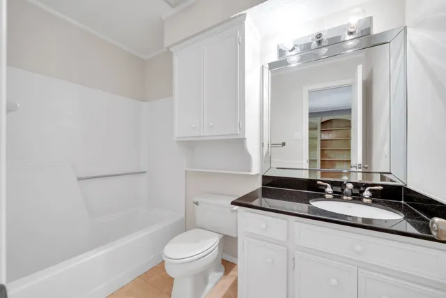 a bathroom with a granite countertop sink a toilet and a mirror