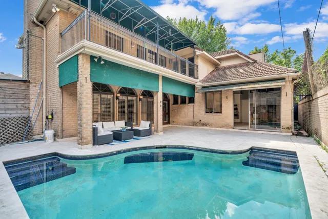a view of a house with a yard patio and swimming pool