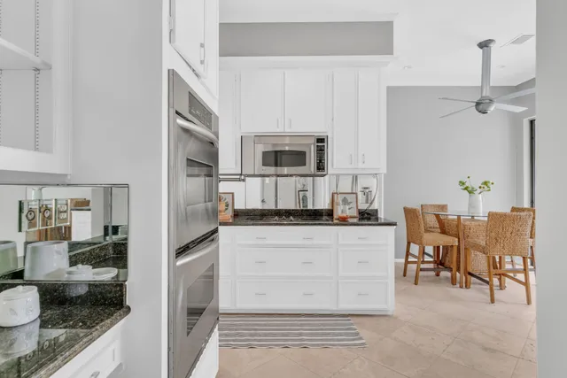 a kitchen with granite countertop a stove a sink and a refrigerator