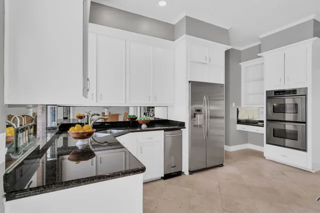 a kitchen with stainless steel appliances granite countertop a refrigerator and a stove