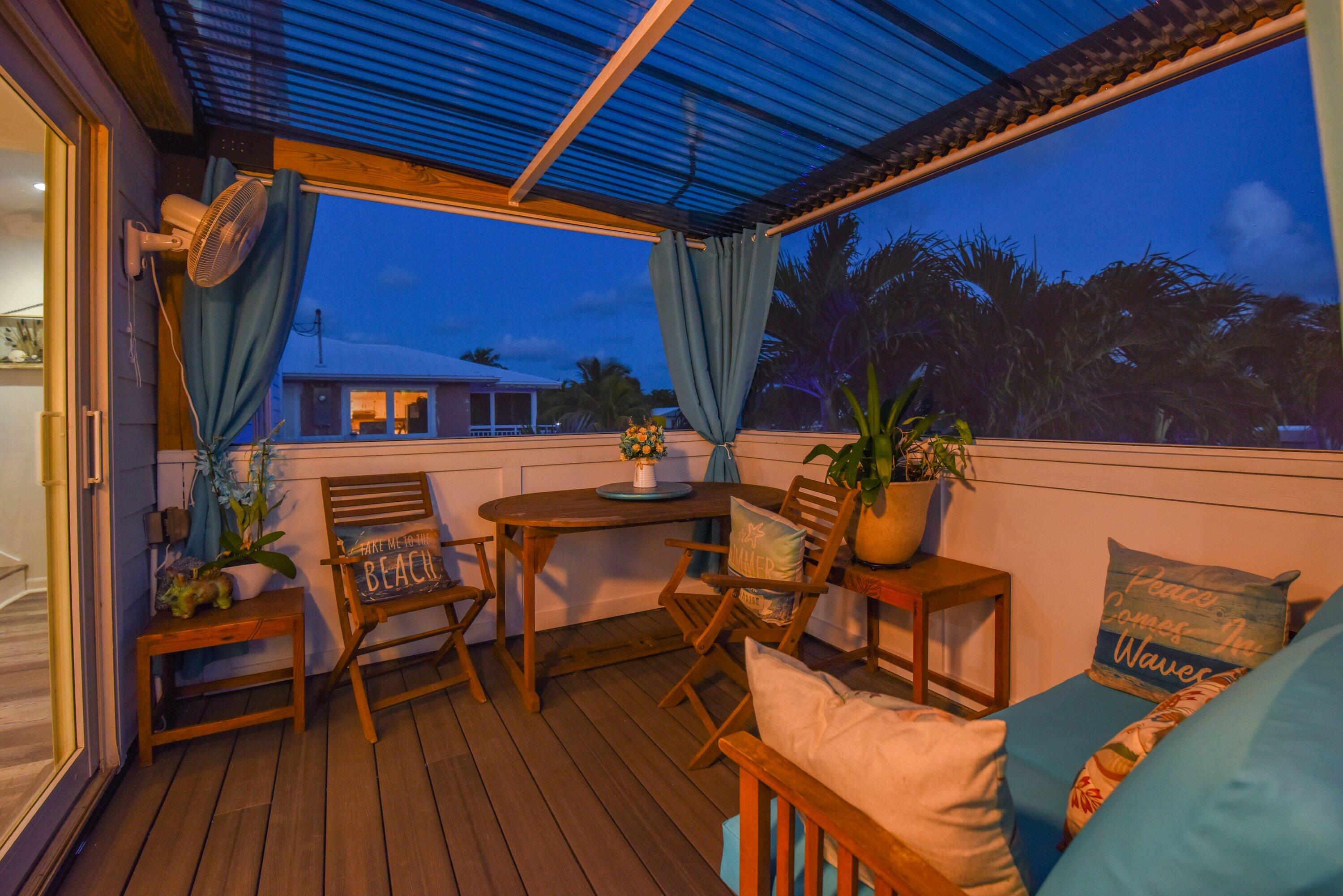 29072 Cedar Drive Big Pine Key, FL 33043 - Photo 19 of 59 a view of a patio with table and chairs with wooden floor and fence