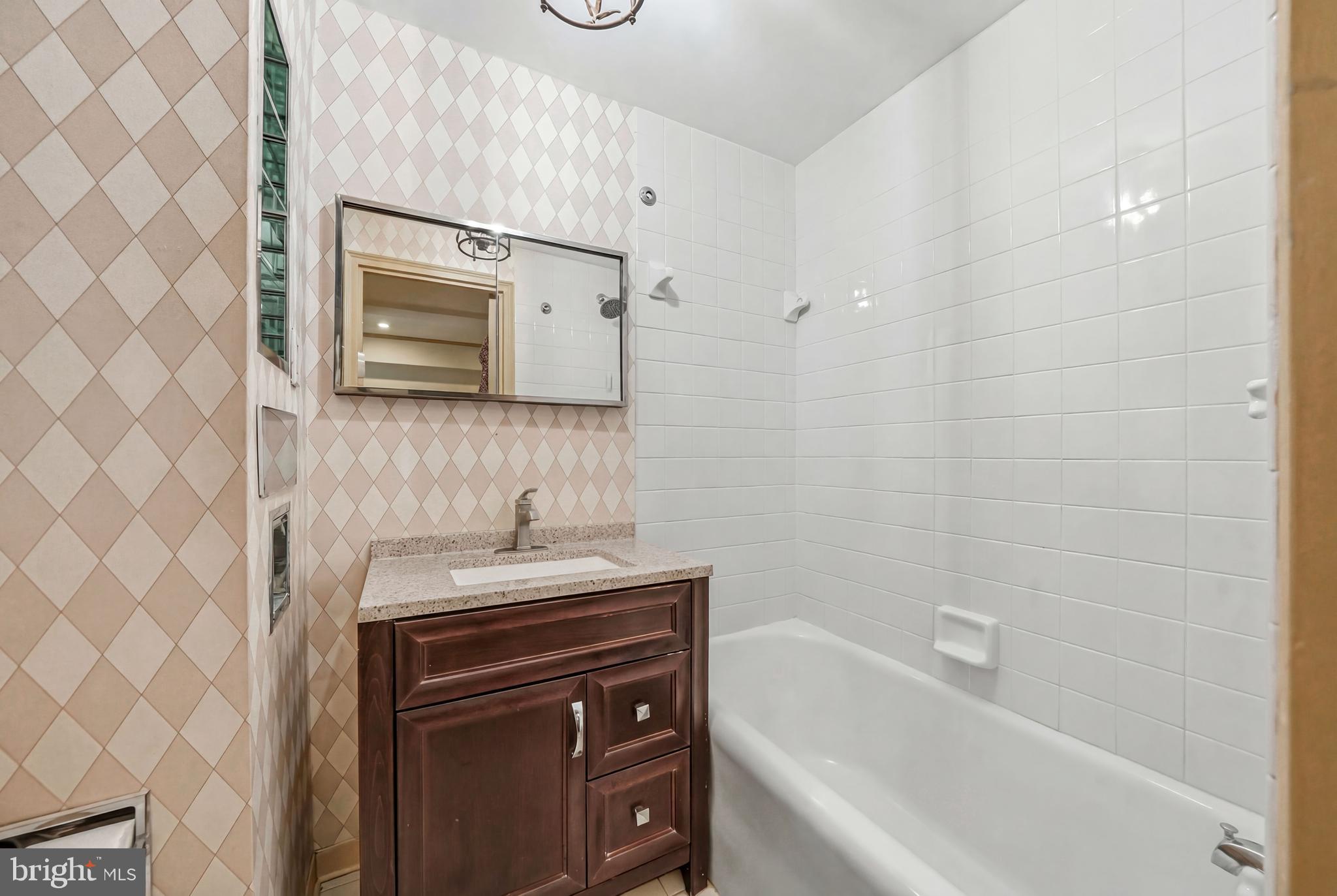 1901 Walnut Street, Unit 6F Philadelphia, PA 19103 - Photo 20 of 32 a bathroom with a sink a vanity and a bathtub