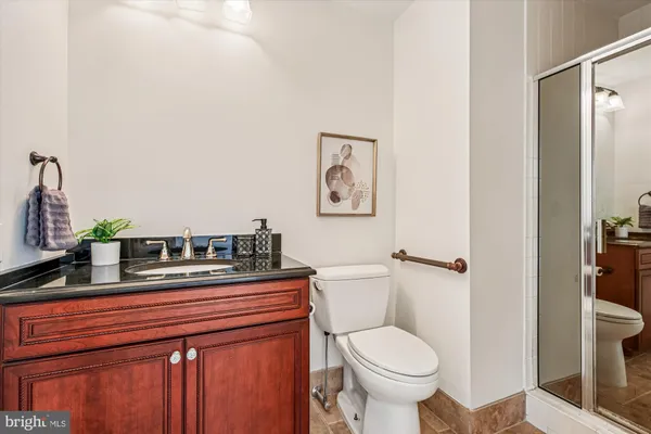 a bathroom with a granite countertop toilet sink and mirror
