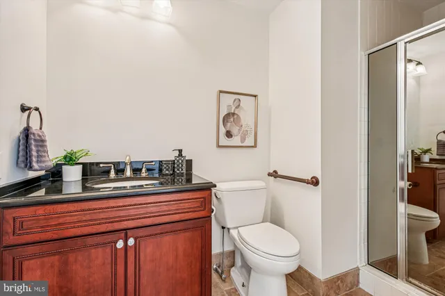 a bathroom with a granite countertop toilet sink and mirror