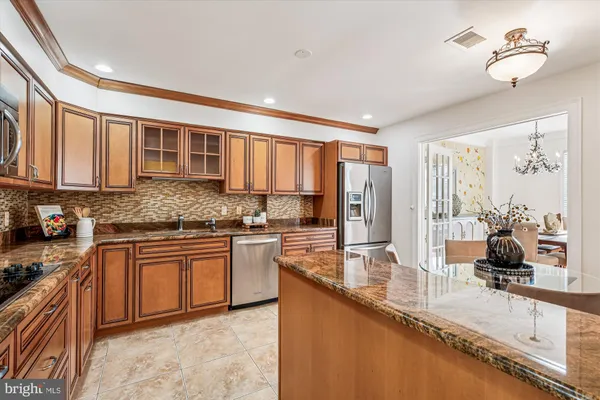 a large kitchen with granite countertop a sink stainless steel appliances and cabinets