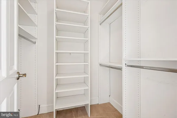 a view of walk in closet with empty racks