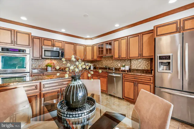 a kitchen with stainless steel appliances granite countertop a refrigerator stove top oven a sink and dishwasher