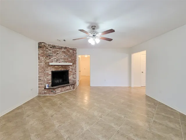 an empty room with chandelier fan