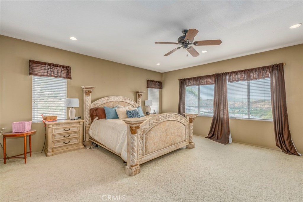 980 Nicholas Place Corona, CA 92882 - Photo 35 of 46 a spacious bedroom with a bed and a chandelier