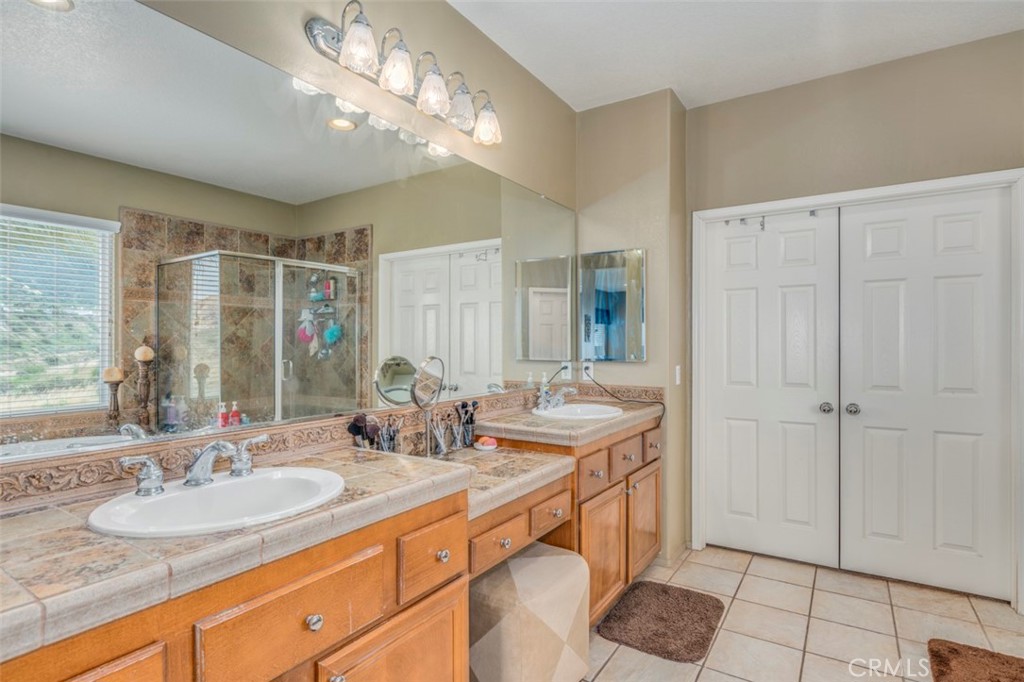 980 Nicholas Place Corona, CA 92882 - Photo 37 of 46 a bathroom with double vanity sinks a vanity and a large mirror