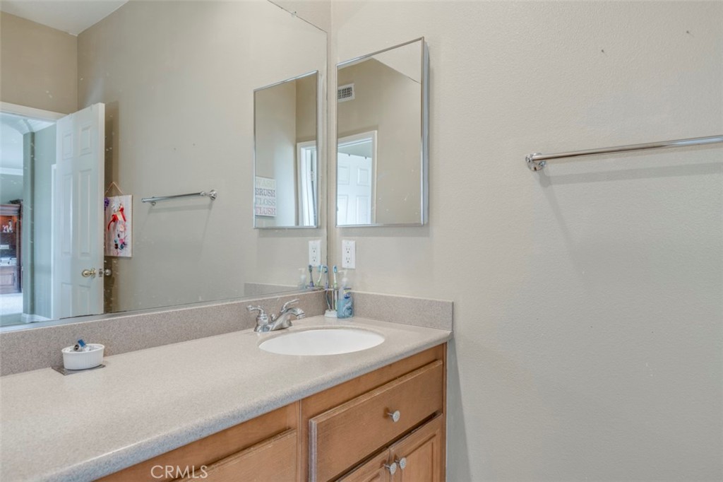 980 Nicholas Place Corona, CA 92882 - Photo 42 of 46 a bathroom with a granite countertop sink and a mirror