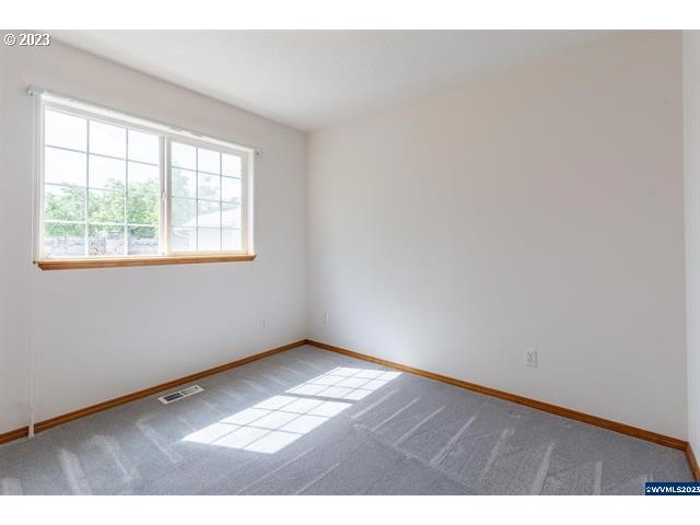 3014 View Lane Lebanon, OR 97355 - Photo 12 of 29 an empty room with wooden floor and windows