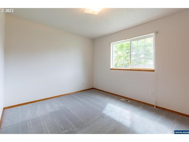 3014 View Lane Lebanon, OR 97355 - Photo 17 of 29 an empty room with wooden floor and windows