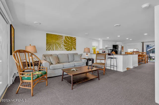 a living room with furniture and kitchen view