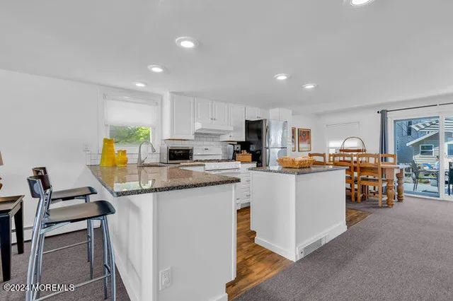 a kitchen with stainless steel appliances kitchen island granite countertop a sink and cabinets
