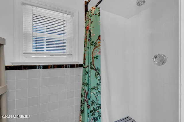 a bathroom with a window and a shower curtain