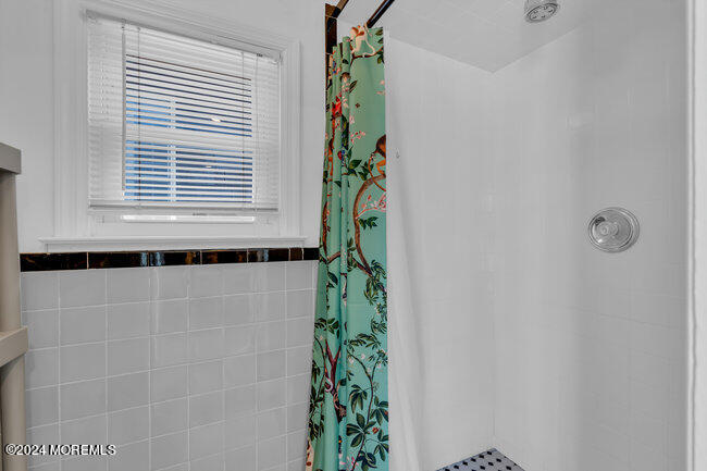157 Beach Front Manasquan, NJ 08736 - Photo 24 of 47 a bathroom with a window and a shower curtain