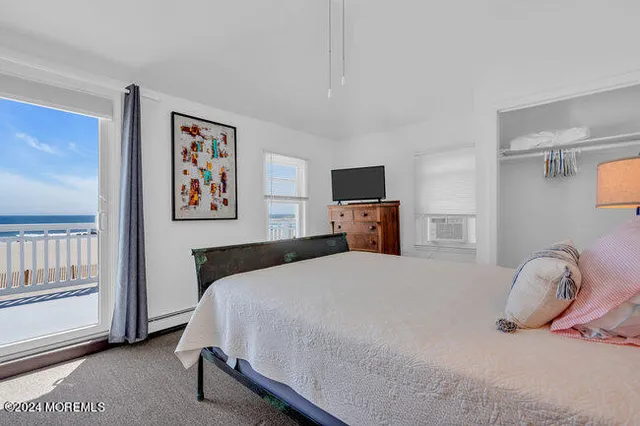 a bedroom with a bed and a tv on the dresser