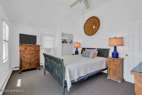 a bedroom with a bed and a lamp on dresser