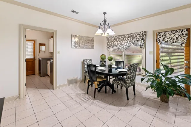 a view of a dining room with furniture and a chandelier