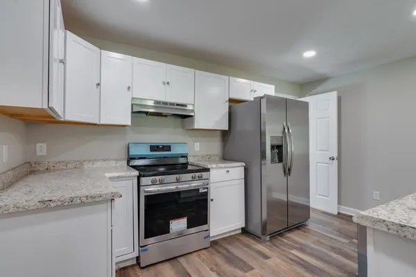 a kitchen with granite countertop a sink and a refrigerator