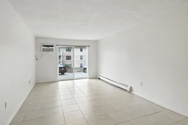 an empty room with windows and ceiling fan