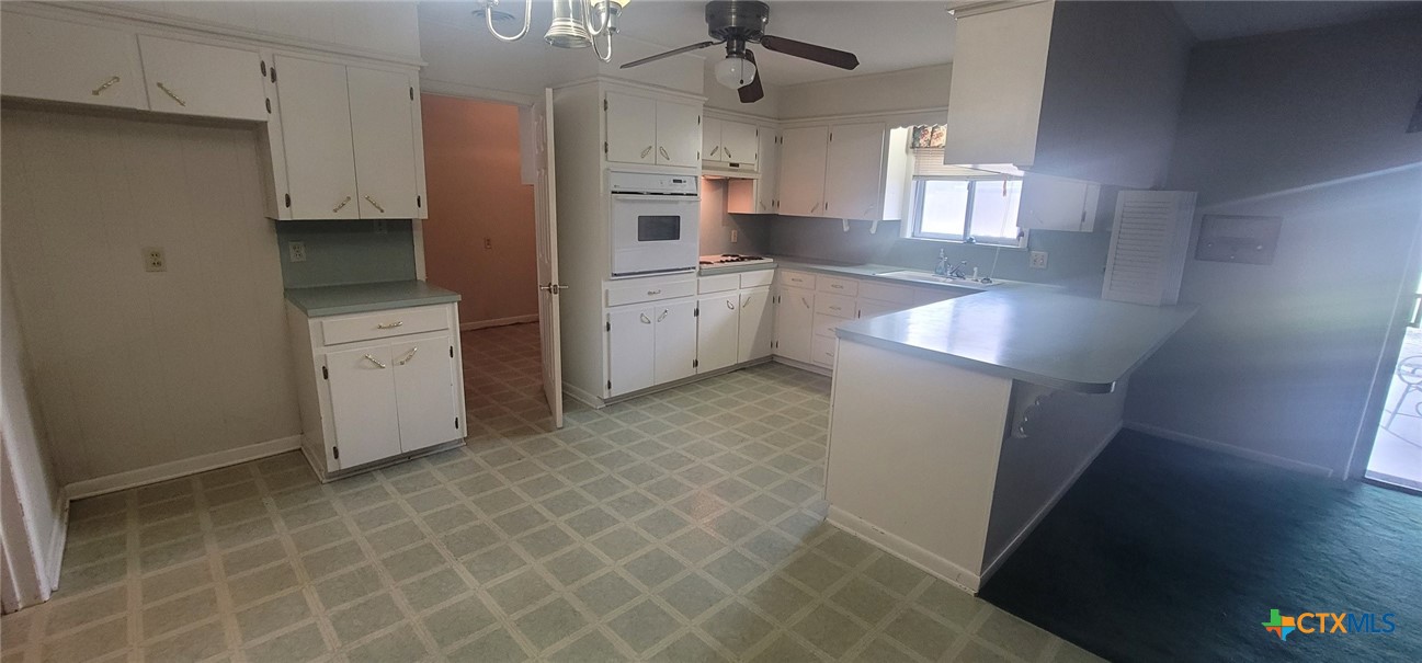 2602 College Drive Victoria, TX 77901 - Photo 16 of 29 a kitchen with white cabinets and white appliances