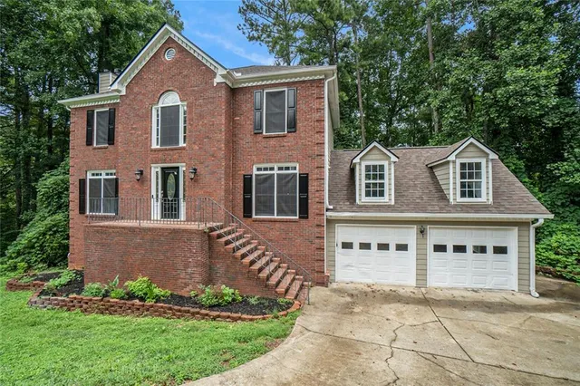 a front view of a house with a garden