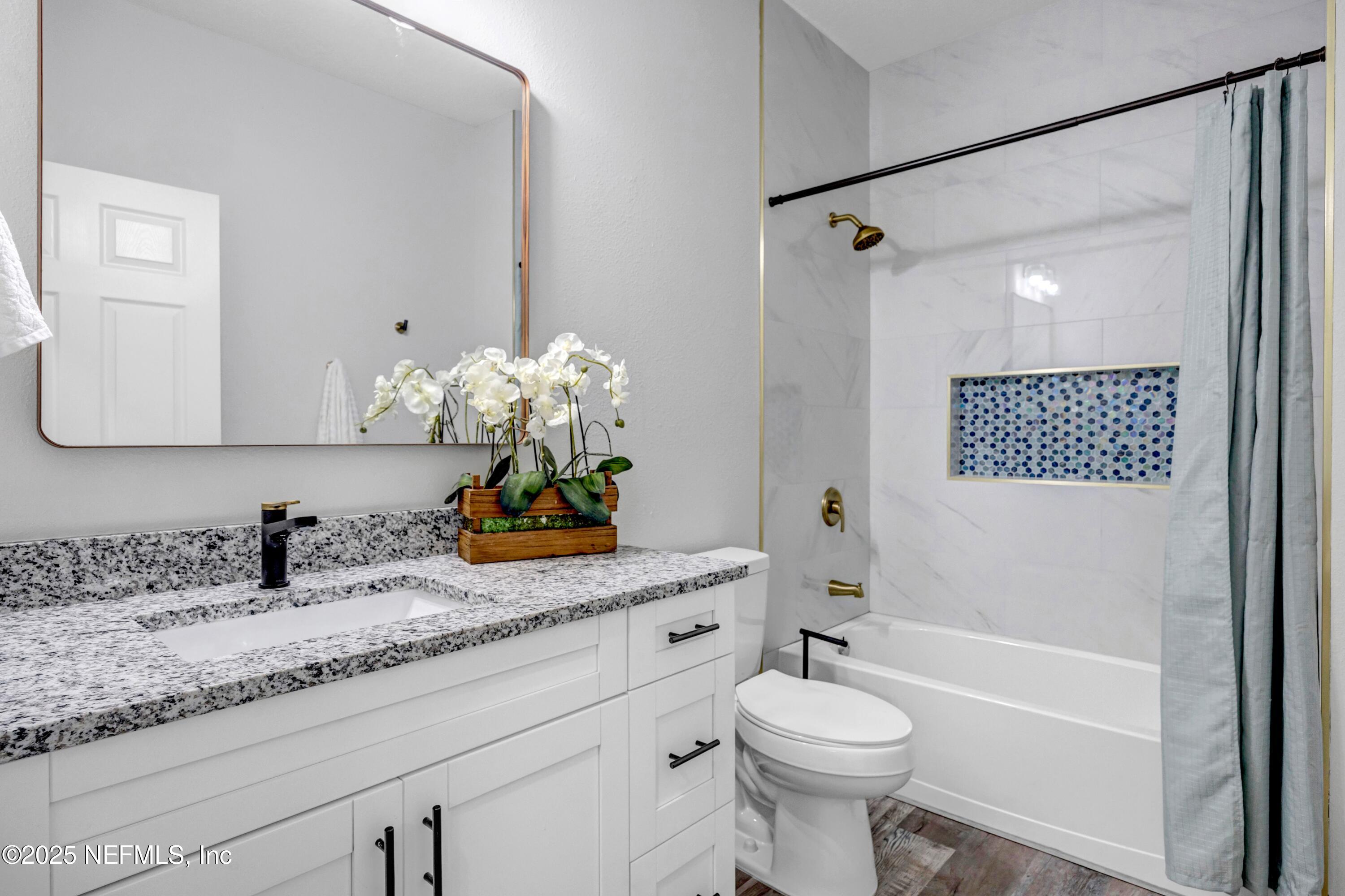 85 Delmonte Street Baldwin, FL 32234 - Photo 32 of 34 a bathroom with a granite countertop sink mirror vanity and toilet