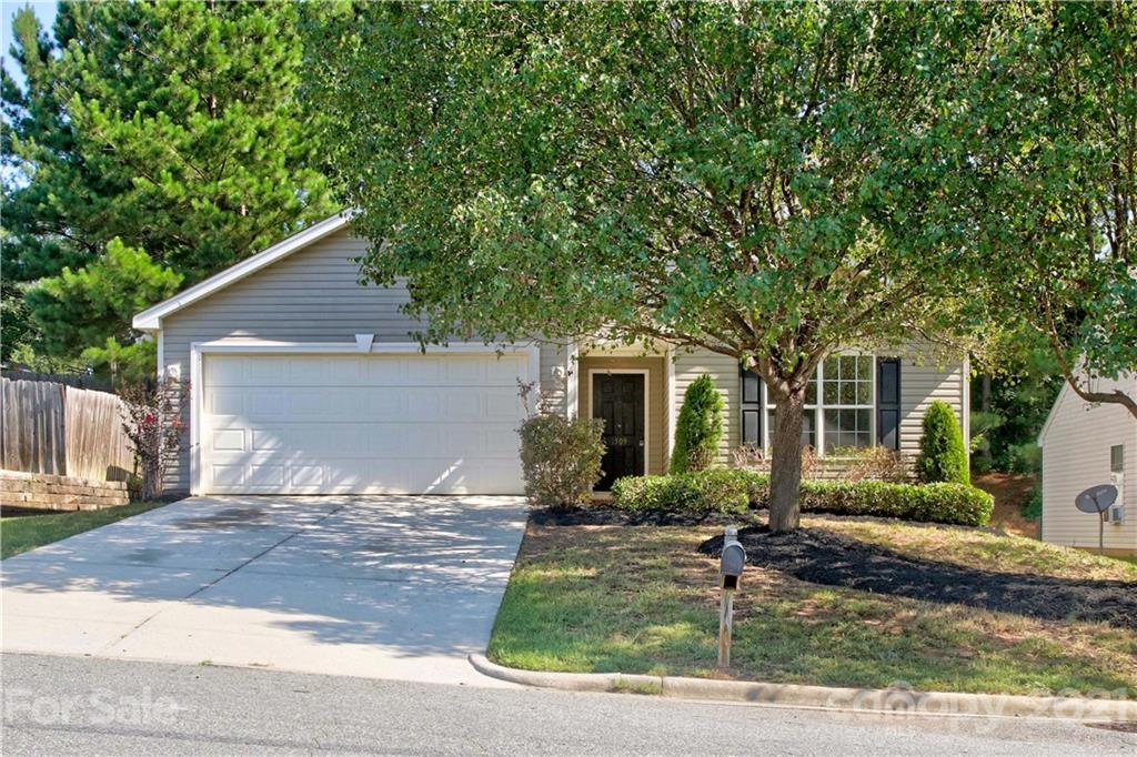 a front view of house with yard and trees around