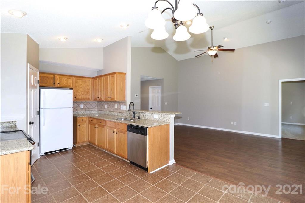 1509 Summit Ridge Lane Kannapolis, NC 28083 - Photo 16 of 37 a kitchen with stainless steel appliances granite countertop a sink a stove a refrigerator and island with wooden floor