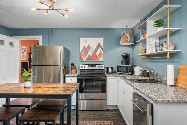 a kitchen with stainless steel appliances granite countertop a stove refrigerator and cabinets