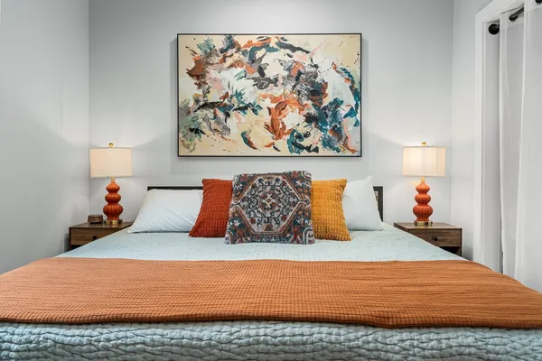 a bedroom with a bed and painting on the wall