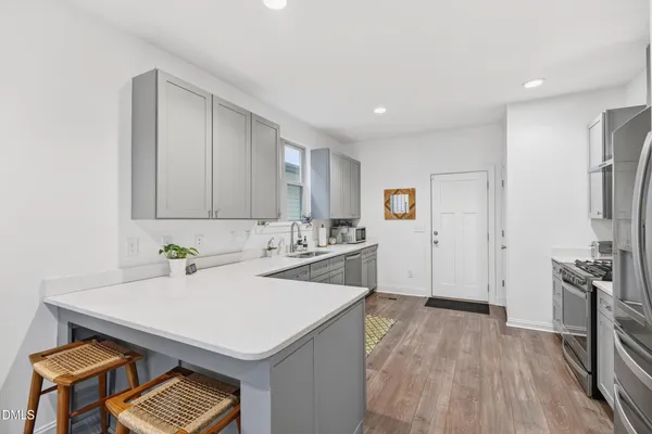 a kitchen with stainless steel appliances white cabinets sink and a window
