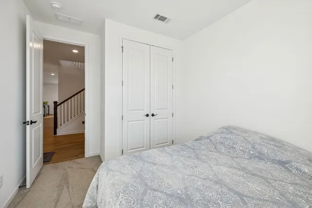 a kitchen with stainless steel appliances kitchen island granite countertop a refrigerator a stove a sink and chairs with wooden floor