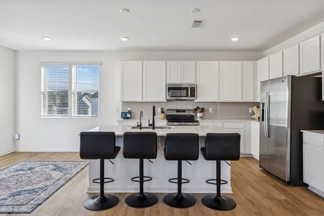 a kitchen with stainless steel appliances granite countertop a sink a stove and a microwave