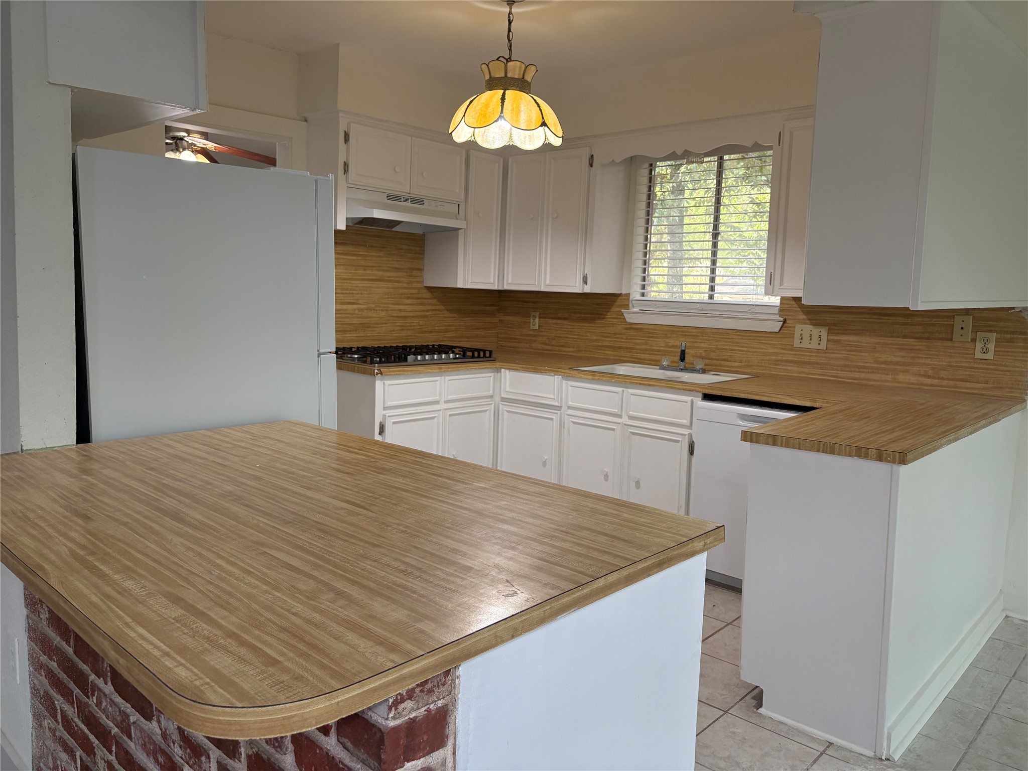 11913 Rennalee Loop Austin, TX 78753 - Photo 11 of 40 A well-lit kitchen with classic white cabinetry and practical wood-look countertops.