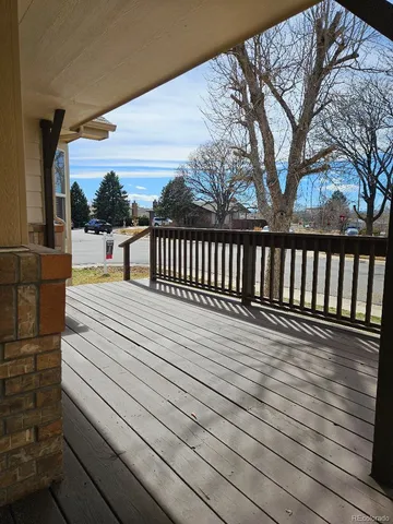 a balcony with wooden floor and fence