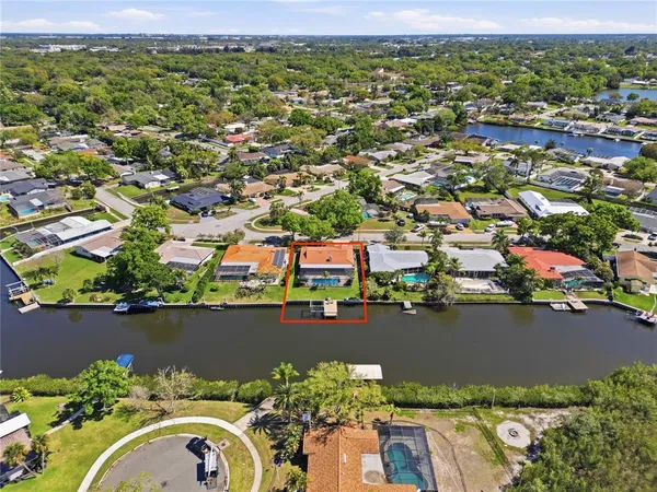 an aerial view of residential houses with outdoor space and lake view
