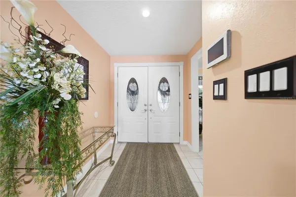 a view of a hallway with entryway and wooden floor