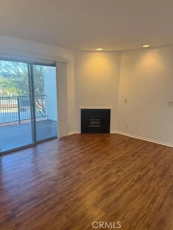 an empty room with wooden floor and ceiling fan