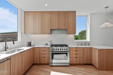 a kitchen with a sink a refrigerator and chairs
