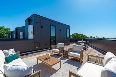 an outdoor living room with patio a couch and chairs