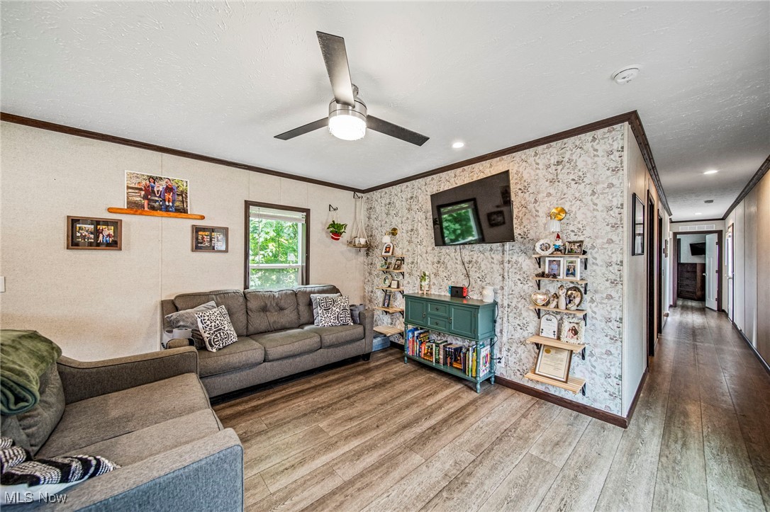202 West Main Road, Unit LOT 13 Conneaut, OH 44030 - Photo 6 of 23 Living room with crown molding, wood finished floors, and a ceiling fan
